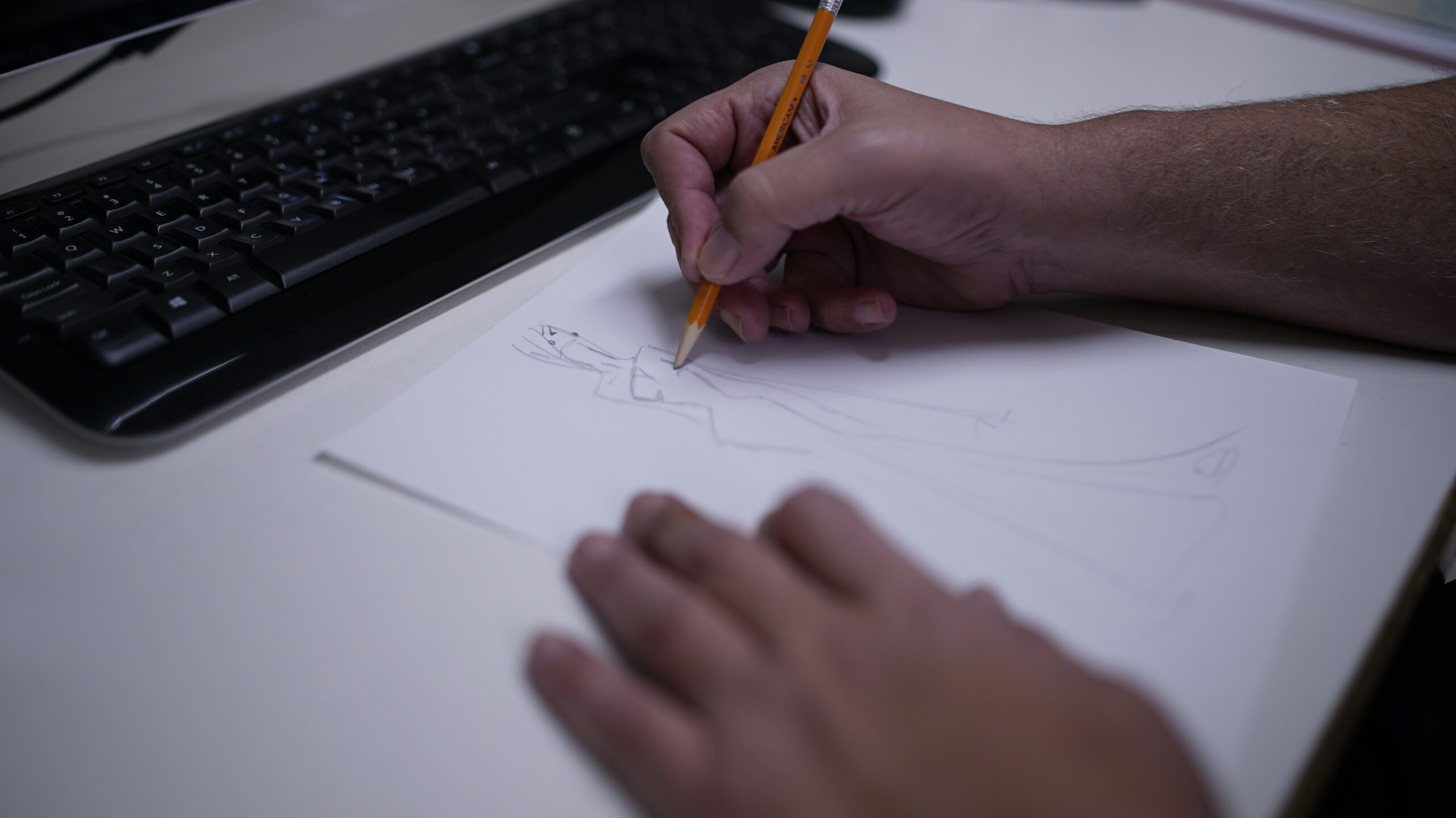 View of a person's hands drawing on paper